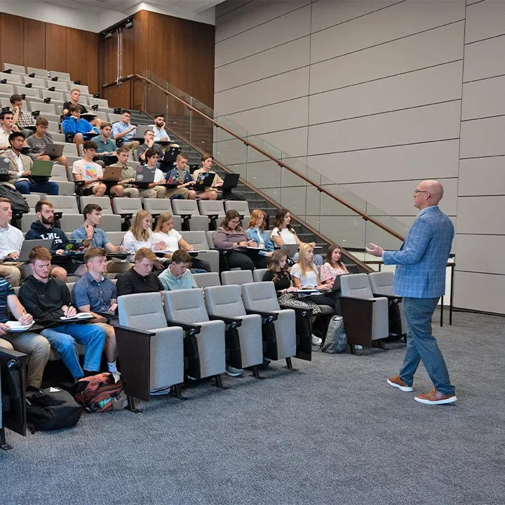 Professor standing in front of classroom teaching.