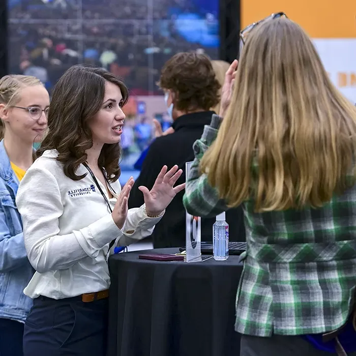 Cedarville admissions counselor speaking to a prospective student at an event.